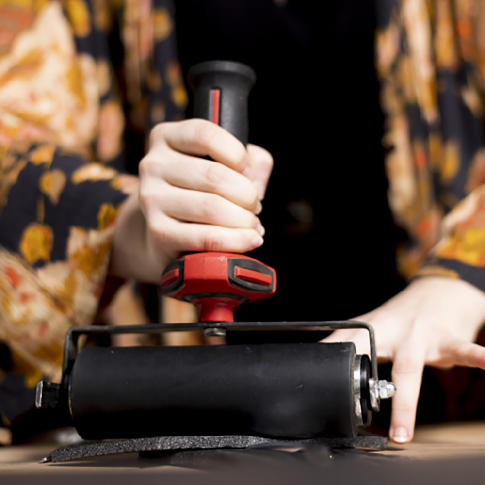 The Artist's hands holding printmaking equipment